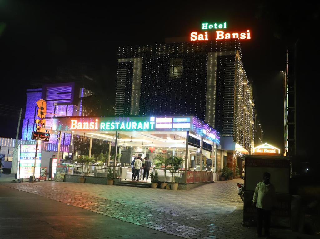 una calle por la noche con un hotel y un restaurante en Hotel Sai Bansi, en Shirdi
