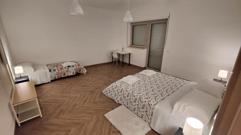 Kleines Zimmer mit 2 Betten und einem Schreibtisch. in der Unterkunft Locanda del Viaggiatore in LʼAquila