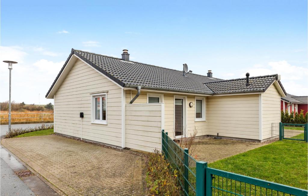 ein weißes Haus mit einem Zaun davor in der Unterkunft Stunning Home In Dagebll With 1 Bedrooms And Wifi in Dagebüll