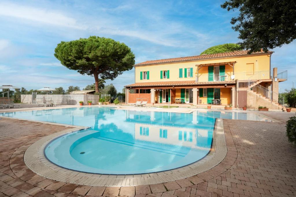 une grande piscine en face d'une maison dans l'établissement Ombra Verde Residence e B&B, à Follonica