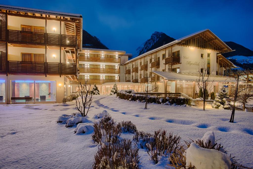 um hotel na neve à noite em Hotel Alpenblick em Luttach