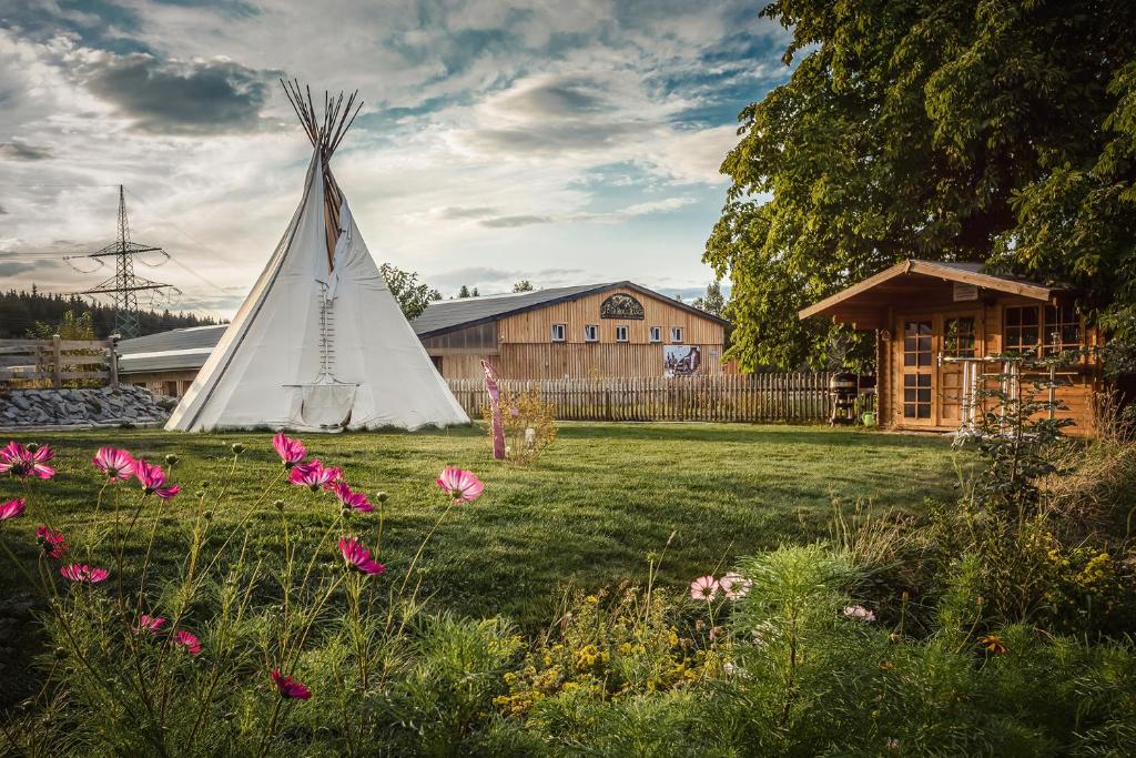 un tipi blanco en un patio con flores en Ranchhouse Bubble - Westernstable - Horse, en Elterlein