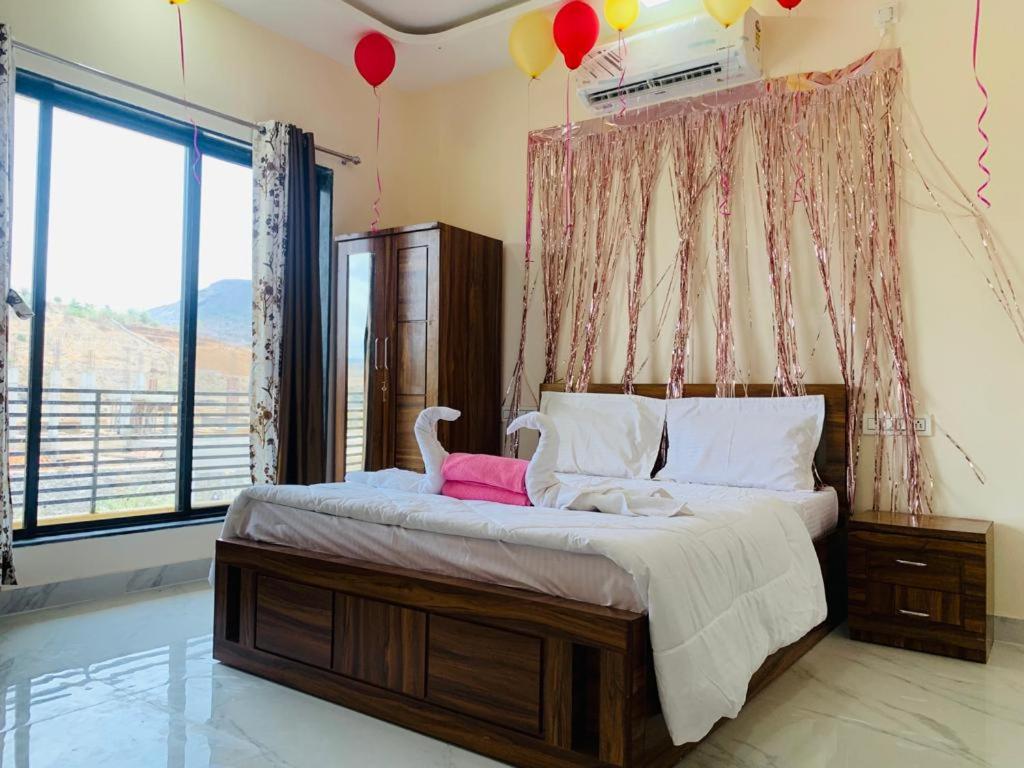 a bedroom with a bed with two swans on it at 5bhk- Nature Villa in Lonavala