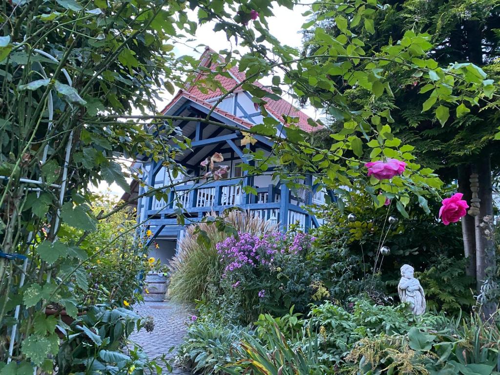 a blue house with a garden with flowers at PARADISE GARDEN in Bad Sooden-Allendorf