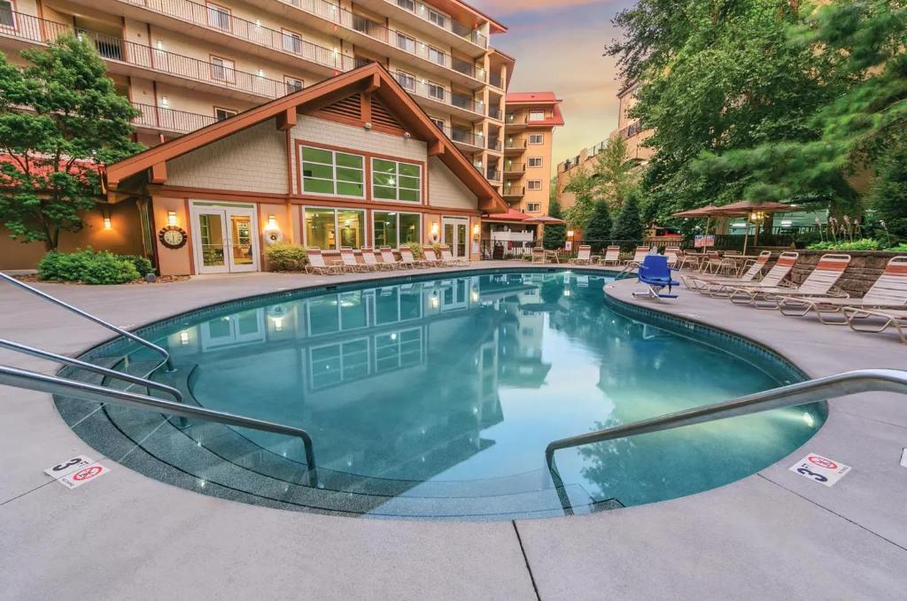 a swimming pool with chairs and a building at Holiday Inn Club Vacations Smoky Mountain Resort in Gatlinburg