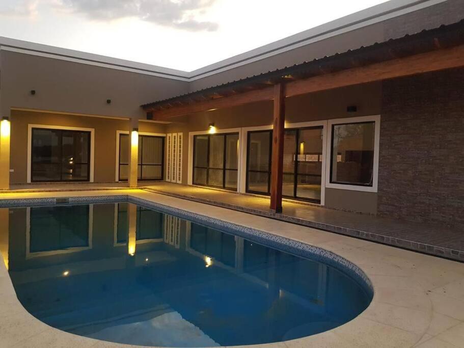 a swimming pool in front of a building at Bitcoins House Los Carpinchos Laguna Brava in Corrientes