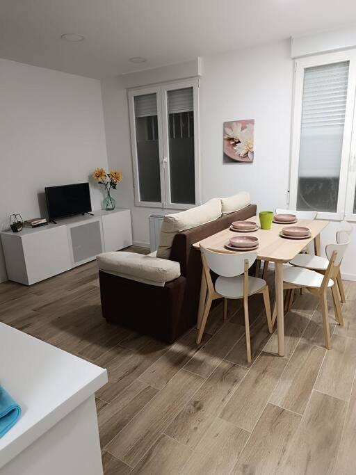 sala de estar con mesa y sofá en Encantador apartamento completo con dos habitaciones en Madrid