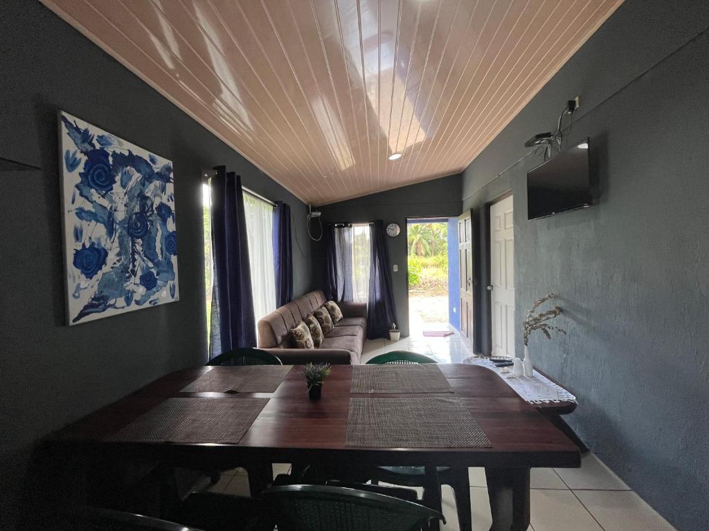 - une salle à manger avec une table et un canapé dans l'établissement Casa Ara Macao, à Paquera