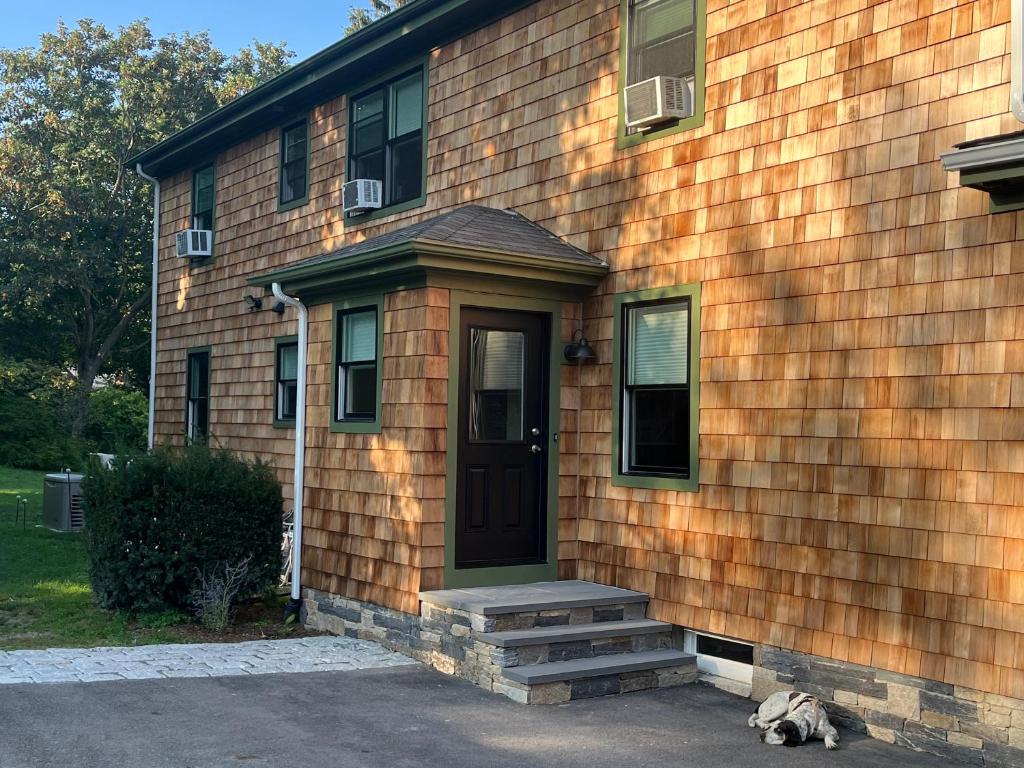 einem Hund, der vor einem Haus mit einer Tür liegt in der Unterkunft Morning Sun in Middletown