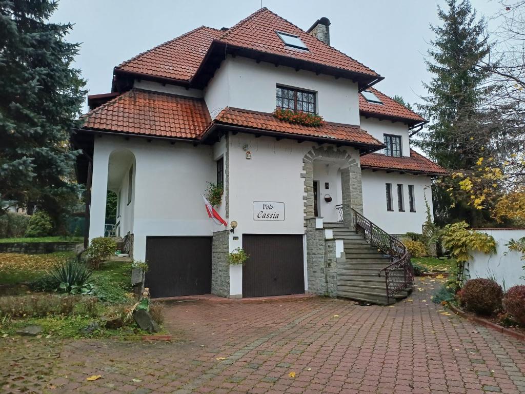 a white house with a red roof at Villa Cassia in Rabka-Zdrój