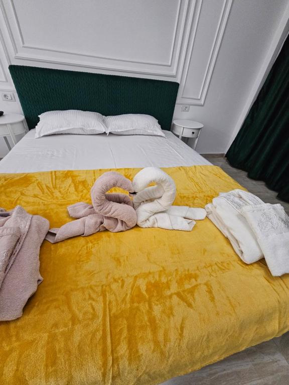 a bed with two swans made out of towels at DIDI Apartament in Craiova