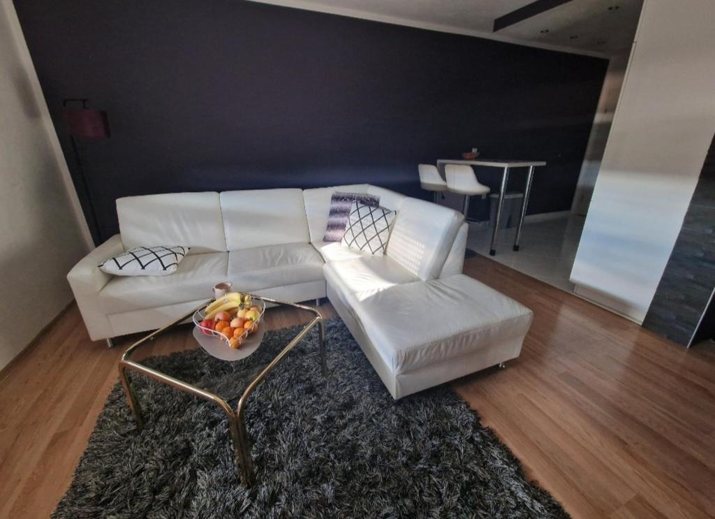 Apartman Samantha في فينكوفسي: غرفة معيشة مع أريكة بيضاء وطاولة