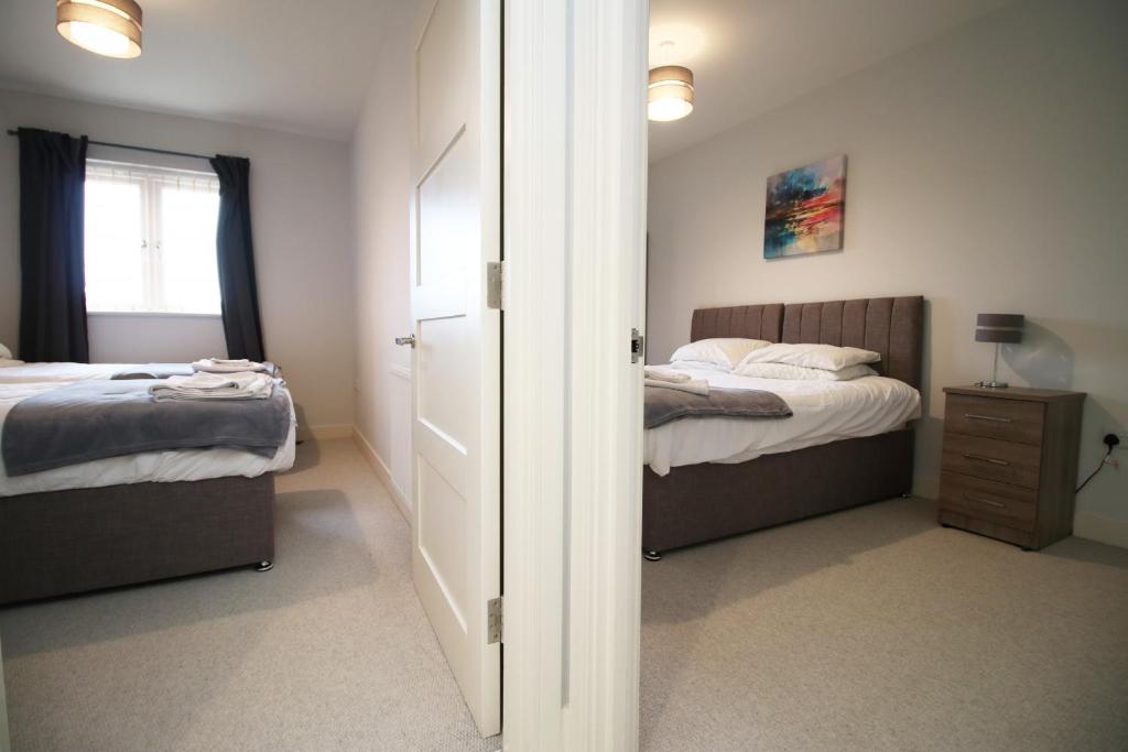 um quarto com duas camas e uma porta que leva a um quarto em K Suites - Carnival Court em Bridgwater
