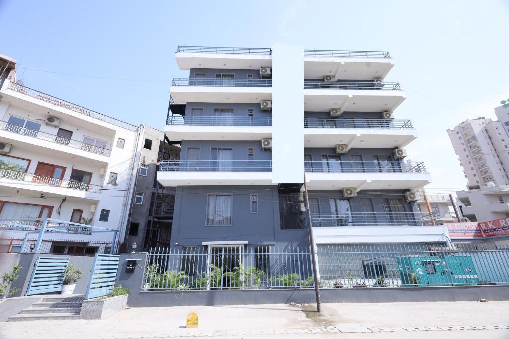 een hoog wit appartementencomplex met balkons bij Hotel Wedlock 51 in Gurgaon