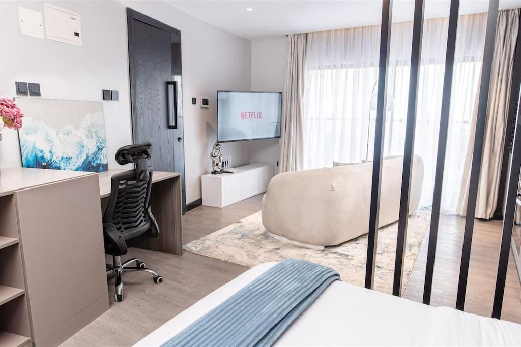 ein Hotelzimmer mit einem Bett, einem Stuhl und einem TV in der Unterkunft Fine Living Sky View in Nairobi