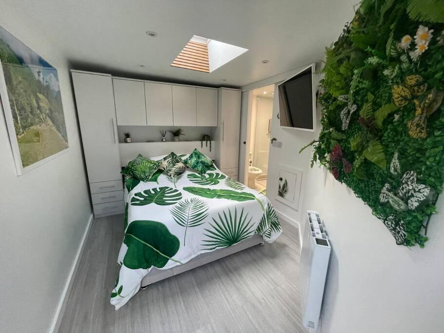 a bedroom with a bed with a green plant on it at Cosy Jungle Cabin With Bathroom 