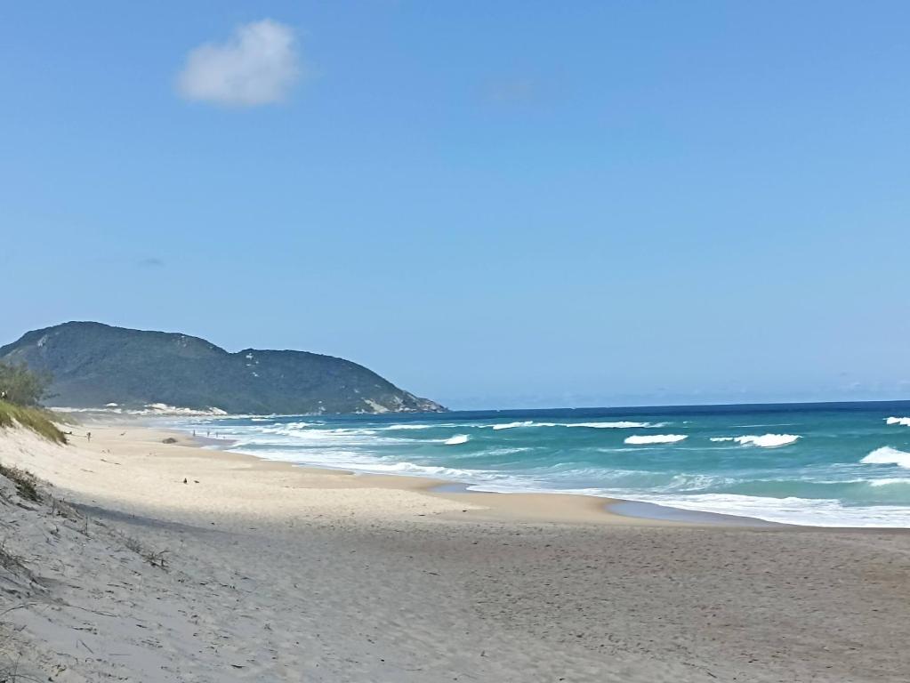 a sandy beach with the ocean in the background at Dunas Tiny House casa 1 in Florianópolis