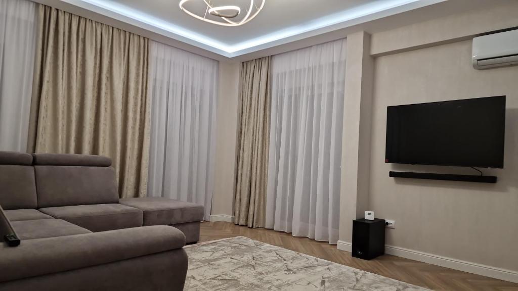 a living room with a couch and a flat screen tv at Freya Residence in Iaşi