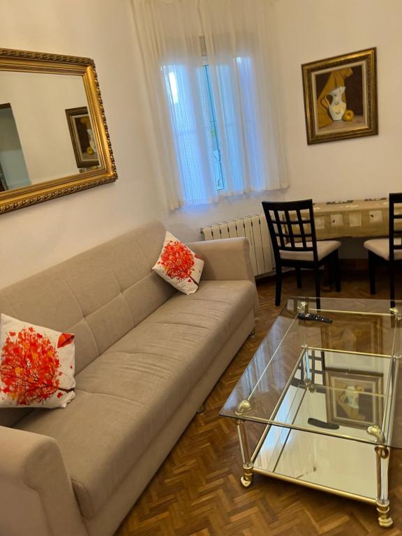 sala de estar con sofá y mesa de cristal en Apartamento Oporto en Madrid