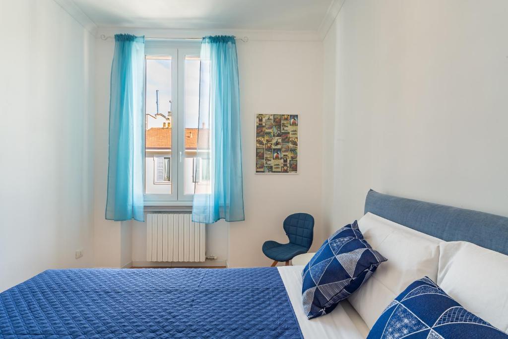 una camera con letto e finestra con tende blu di [Navigli-Centro] Comfort suite con WiFi a Milano