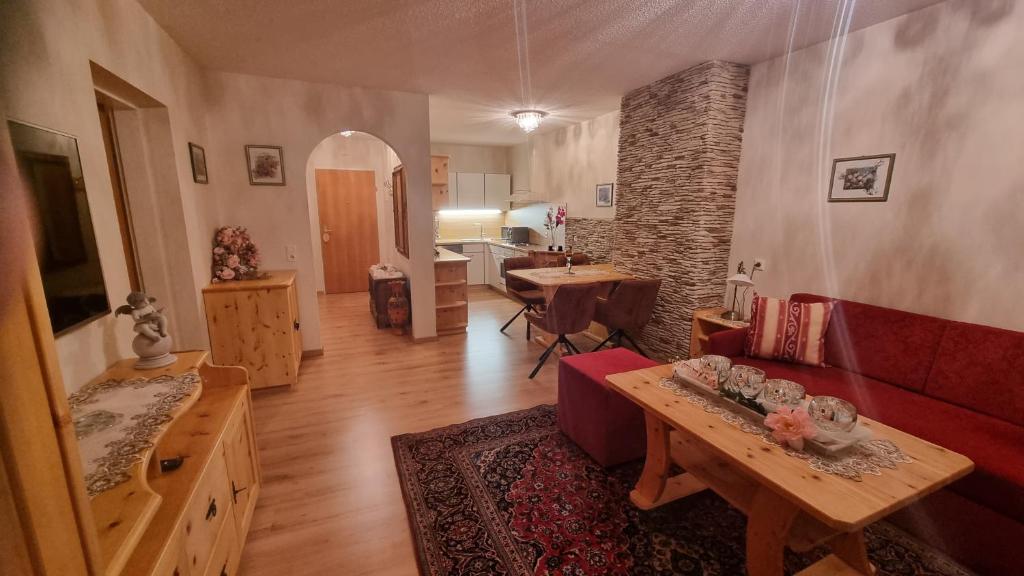 a living room with a red couch and a table at Appartement Michelle in Juns