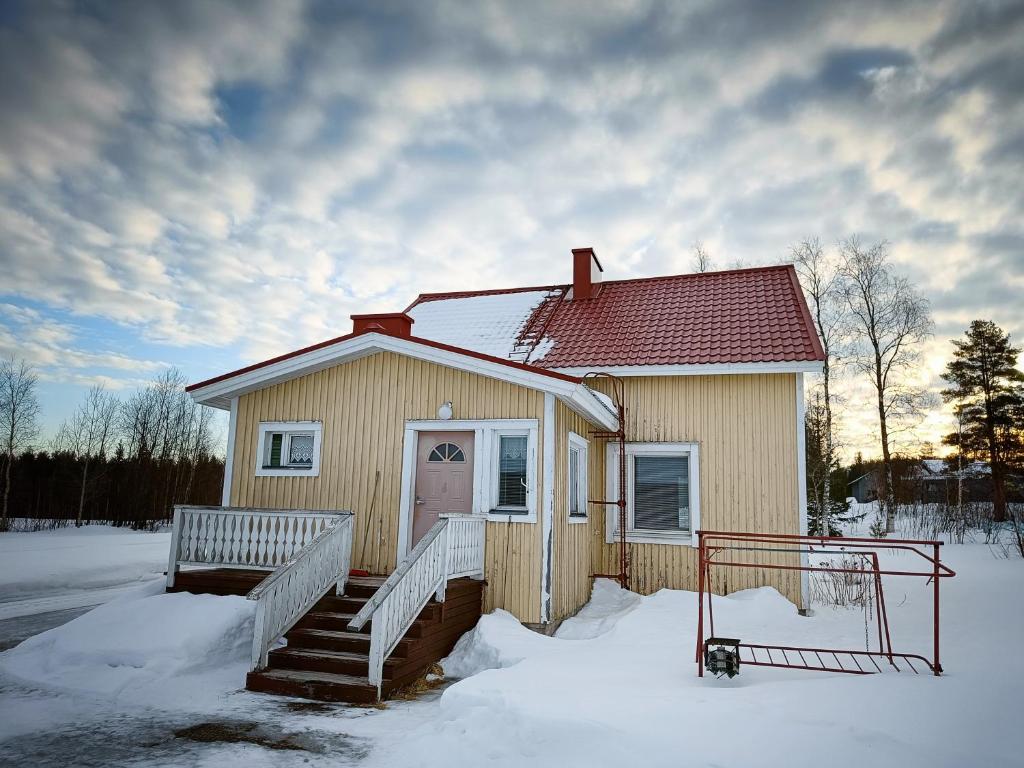 ein kleines Haus im Schnee mit einer Treppe in der Unterkunft Mäki-mummola in Ylitornio