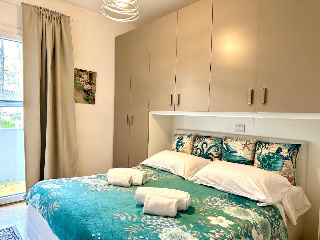 een slaapkamer met een bed met twee handdoeken erop bij Villa Amedea in Lignano Sabbiadoro