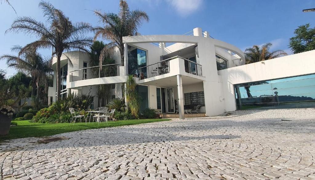 a large white house with palm trees in front of it at Blue Oasis Apartments in Benoni