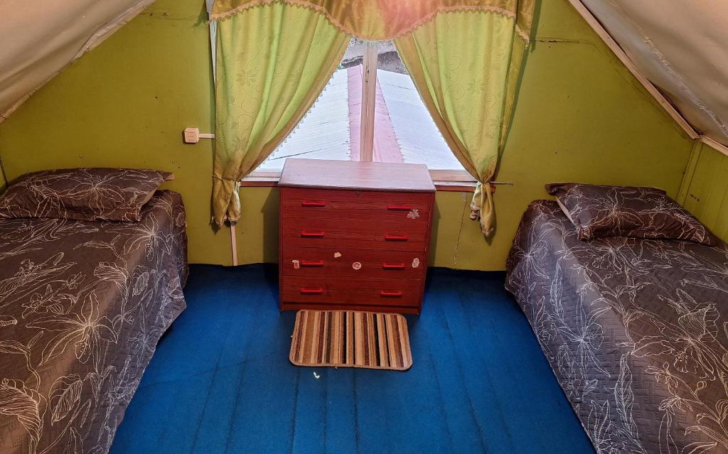 a room with two beds and a dresser in a tent at Casa Pauly in Llanquihue