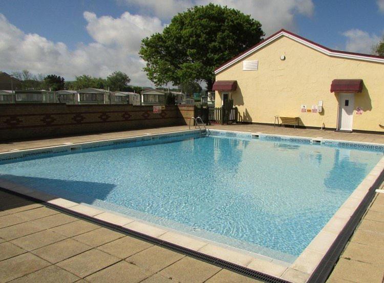 a large blue swimming pool next to a building at H9 Fairway Holiday Park Sandown in Sandown