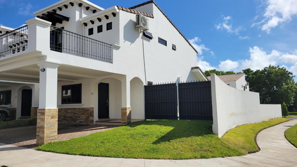a white house with a black fence at New 3 bedroom Home in Managua in Managua