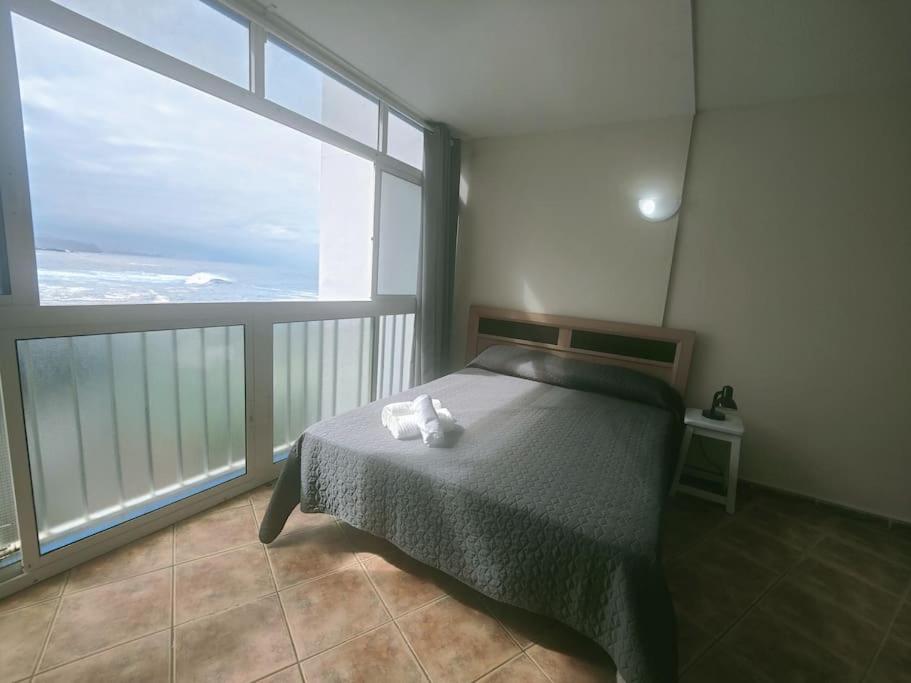 - une chambre avec un lit et une grande fenêtre dans l'établissement Atardecer con vistas al Teide, à Tacoronte