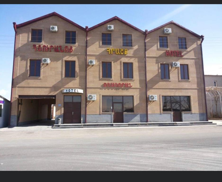 a large building with a sign on the side of it at Hrashq Hotel in Yerevan