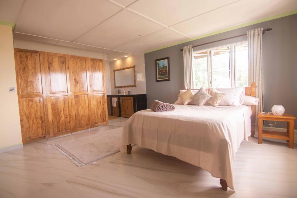 um quarto com uma cama grande e uma janela em Azamat Self-Catering Apartment em Mahé