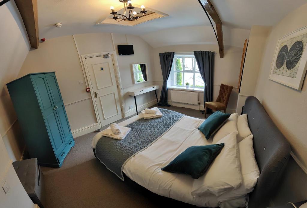 a bedroom with a large bed with a blue door at Kings Arms Hotel in Kirkby Lonsdale