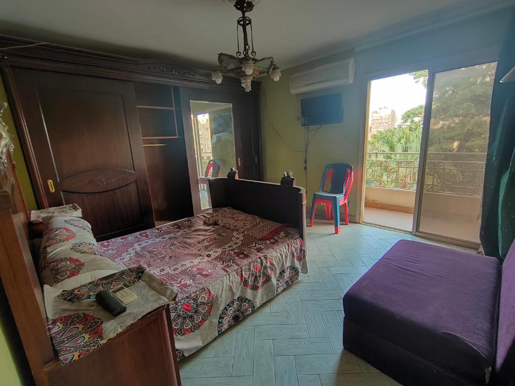 ein Schlafzimmer mit einem Bett und einem Balkon in der Unterkunft شقه مفروشه مميزه جدا لعائله بالدقي in Kairo