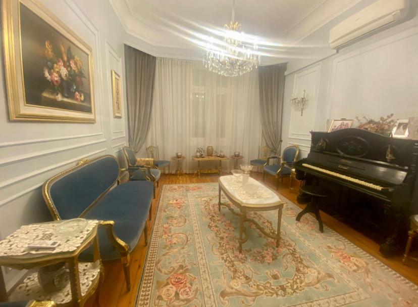 - un salon avec un piano à queue et des chaises dans l'établissement Cozy Room in Garden City for females, au Caire