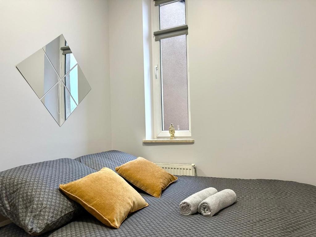 um quarto com uma cama com duas almofadas e uma janela em MMRent Heaven Room em Gdańsk