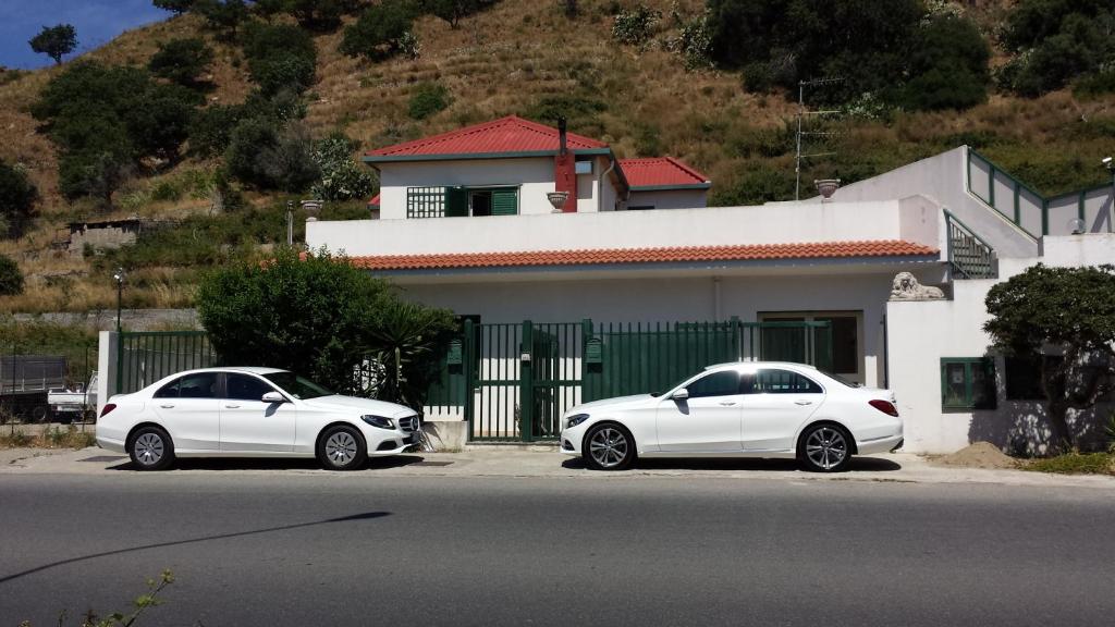 two white cars parked in front of a house at B&B Villa Angelica in Mili Marina