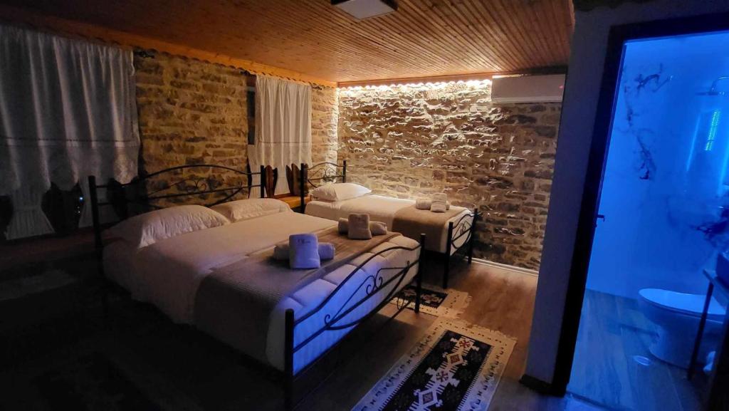 a bedroom with a large bed and a television at Guest House Hasko in Gjirokastër