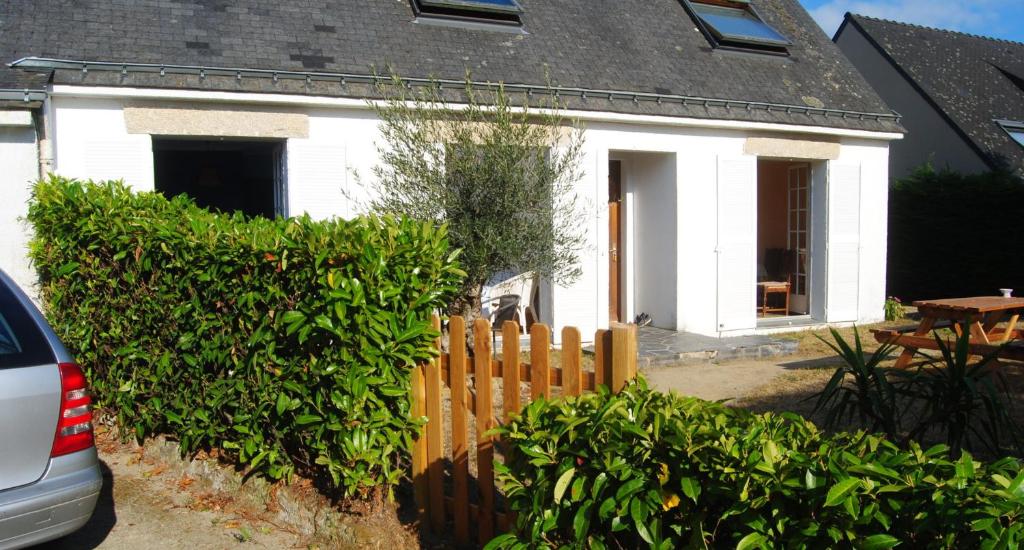 een wit huis met een hek ervoor bij Location Golfe du Morbihan in Arradon
