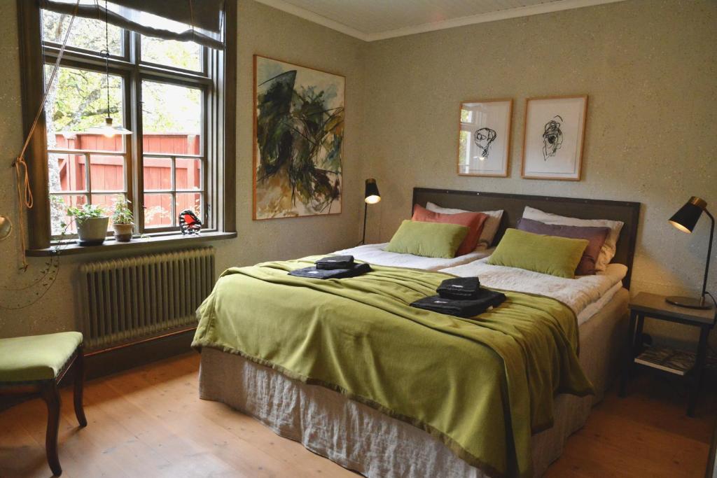 ein Schlafzimmer mit einem großen Bett und einer grünen Decke in der Unterkunft Lilla Hotellet in Tranemo