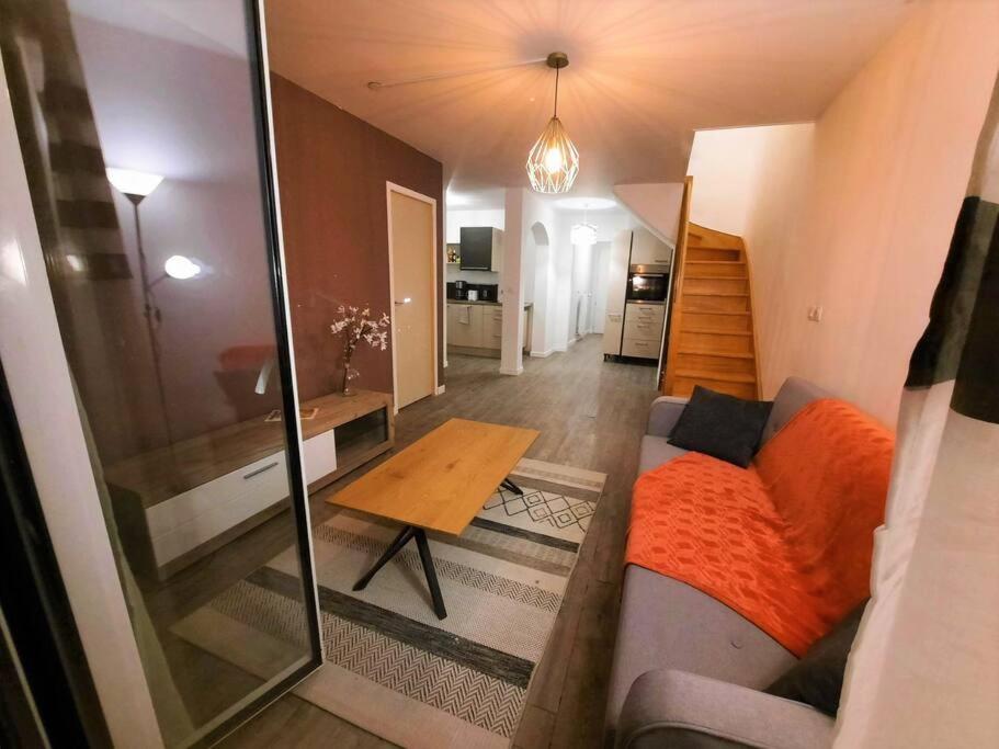 a living room with a couch and a table at La Chambre Saint Jacques &amp; Rennes in Saint-Jacques-de-la-Lande