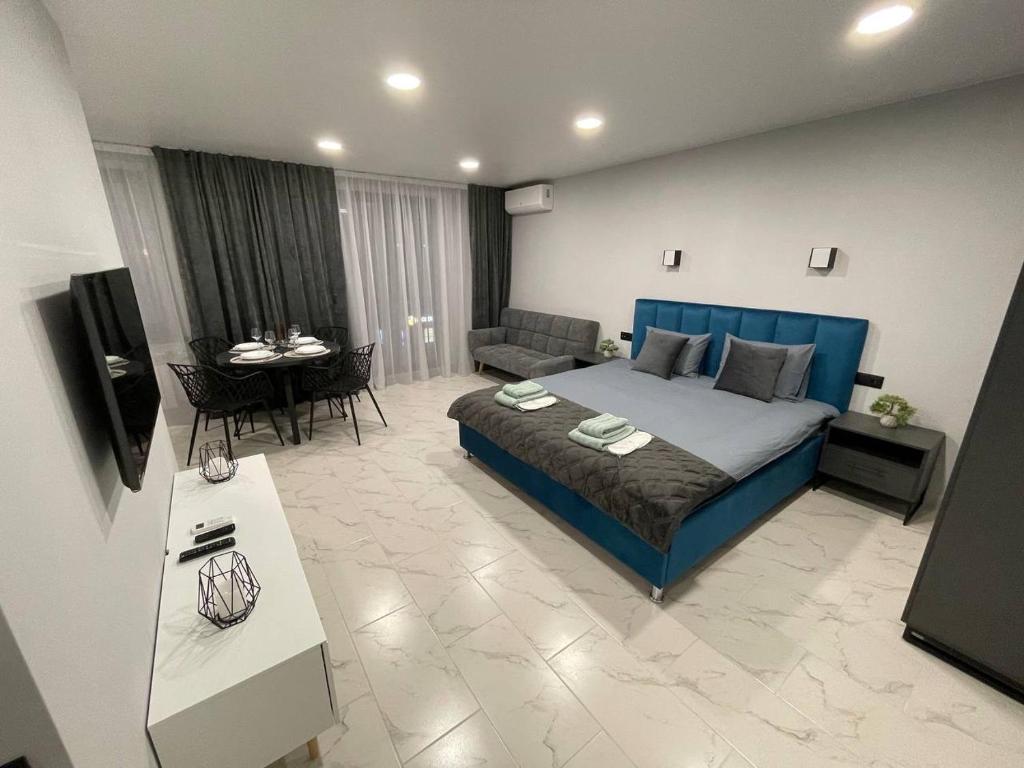 ein Schlafzimmer mit einem blauen Bett und ein Wohnzimmer in der Unterkunft Apartment with the best location in Chişinău