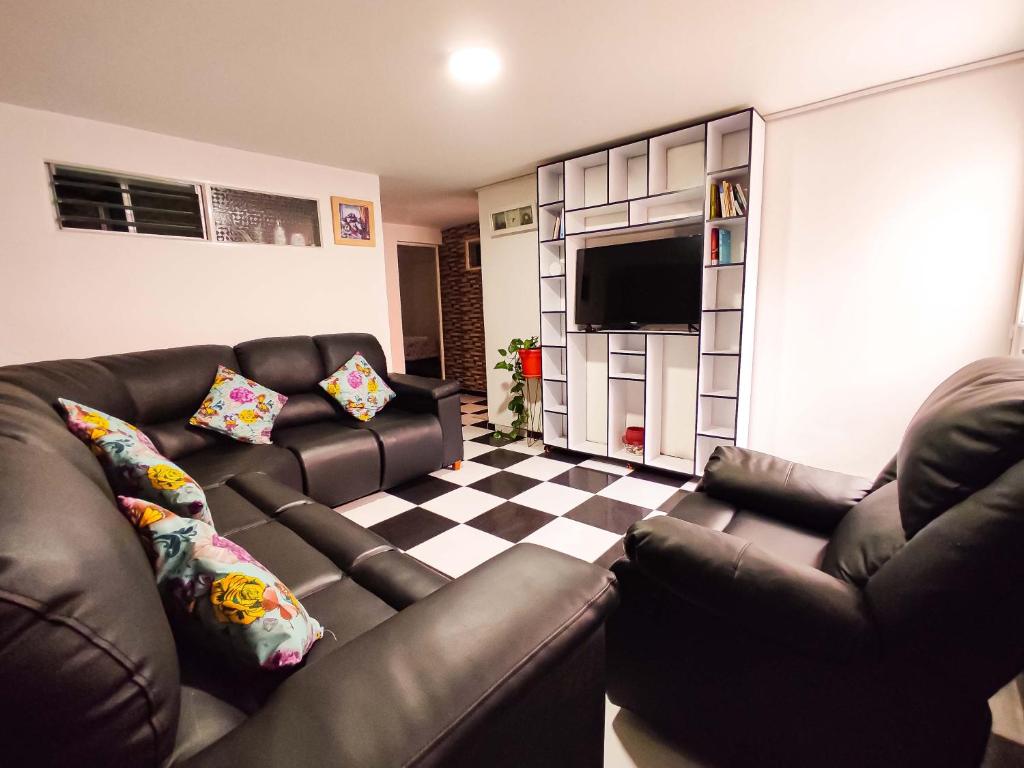 a living room with a couch and a television at Precioso apartamento cerca del Aeropuerto de Bogta in Bogotá