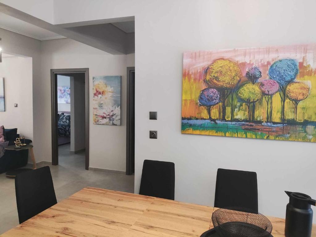 a dining room with a table and a painting on the wall at Phily's in Volos
