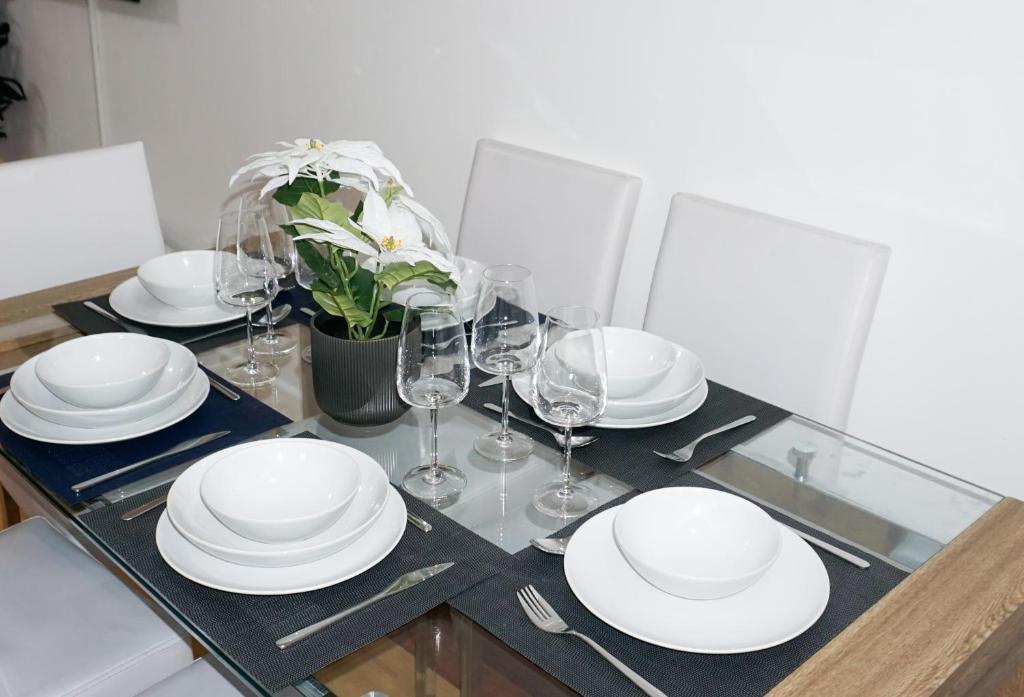 a dining table with white plates and wine glasses at The Oasis in Wigan