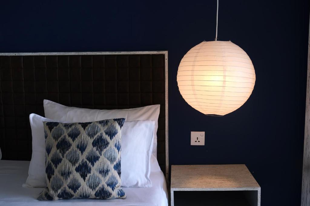 a bedroom with a bed with a lamp and a table at BeachMirissa Hotel in Mirissa