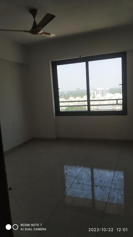 Habitación vacía con ventana y ventilador de techo. en Shubh Antilia, en Ahmedabad