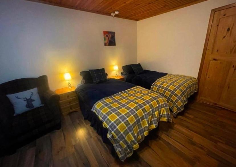 1 dormitorio con 2 camas, sofá y 2 lámparas en Sea View B & B, en Ulsta